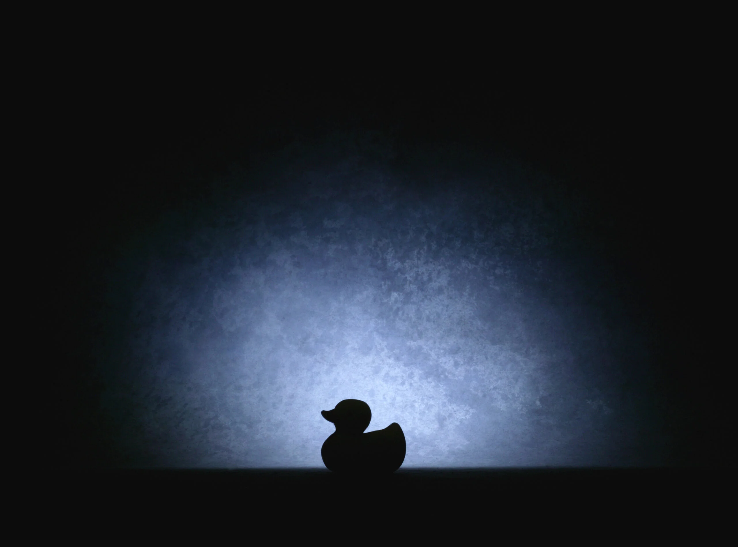 Silhouette of a sitting duck in spotlight representing cybersecurity risks without managed IT services.